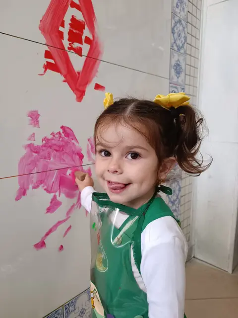 Menina da Jeito de Ser pintando a parede com tinta rosa